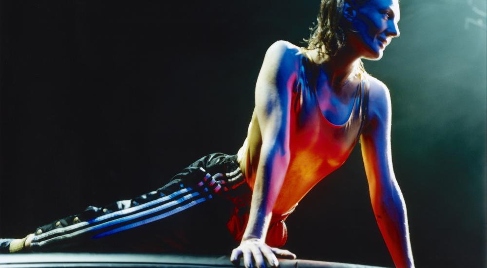 A person lying on the roof of a car