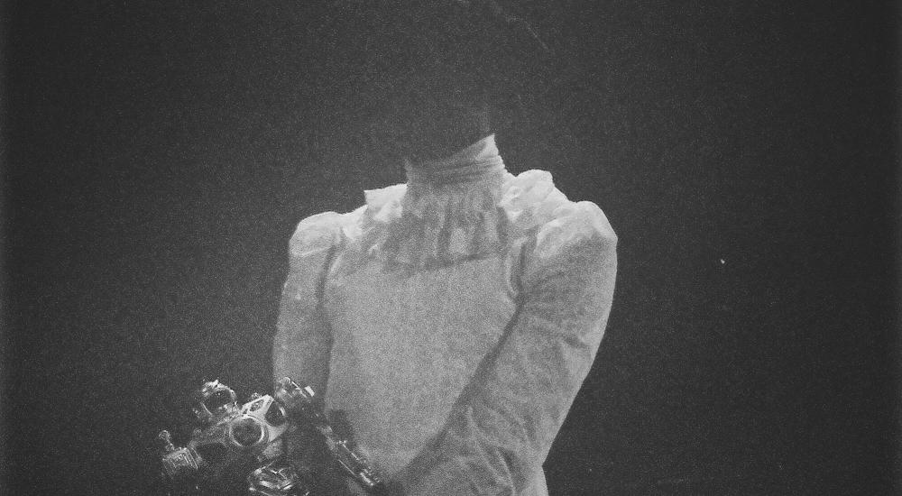 Mackenzy wearing a white lace dress, holding a toy robot