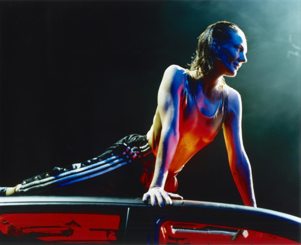 A person lying on the roof of a car