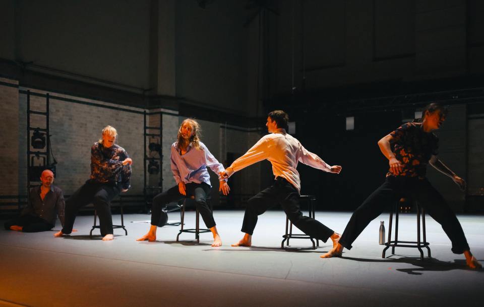 4 dancers moving on chairs, 1 lying on the floor