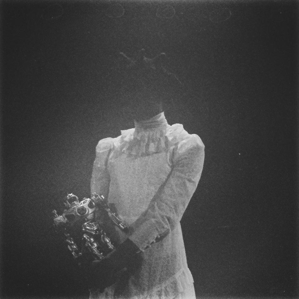 Mackenzy wearing a white lace dress, holding a toy robot