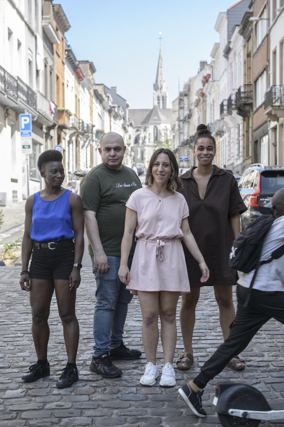 For people posing on the street while someone on an electric scooter rides by